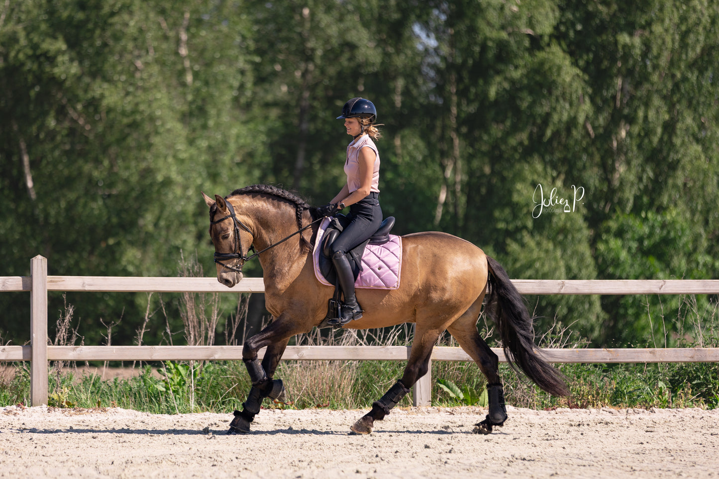 Vrouw op een paard in een rijhal met lichtroze zadeldek van THE HORSEBOX LIGHT PINK