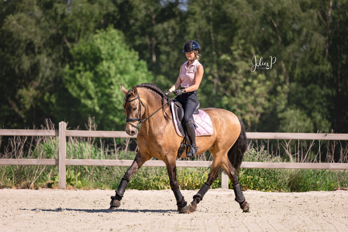 Ruiter op een paard in een lichtroze zadel en sportieve outfit tijdens de training in de natuur LIGHT PINK
