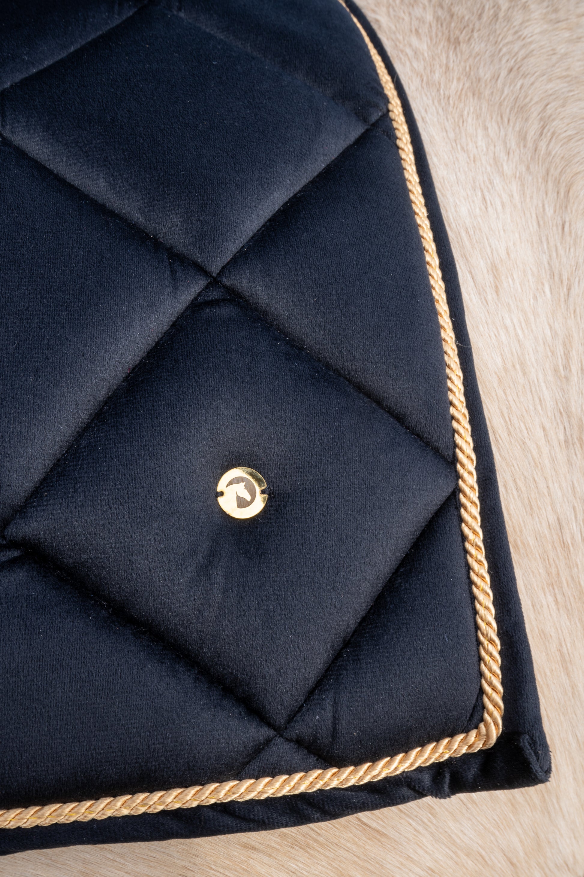 Zwart fluwelen zadeldekje met goudkleurige afwerking van THE HORSEBOX
